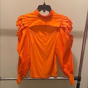 Orange mock neck blouse with puff sleeves and ruffled cut out details